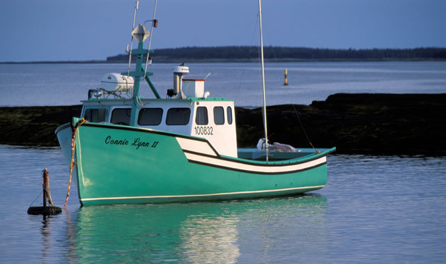 Colorful fishing boat reflecting in evening light. Blue rocks fishing village near Lunenburg, Nova Scotia, Canada